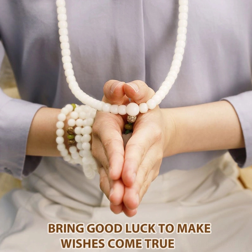 Hands holding white bodhi prayer mala in meditative prayer pose, mindfulness practice hand close-up