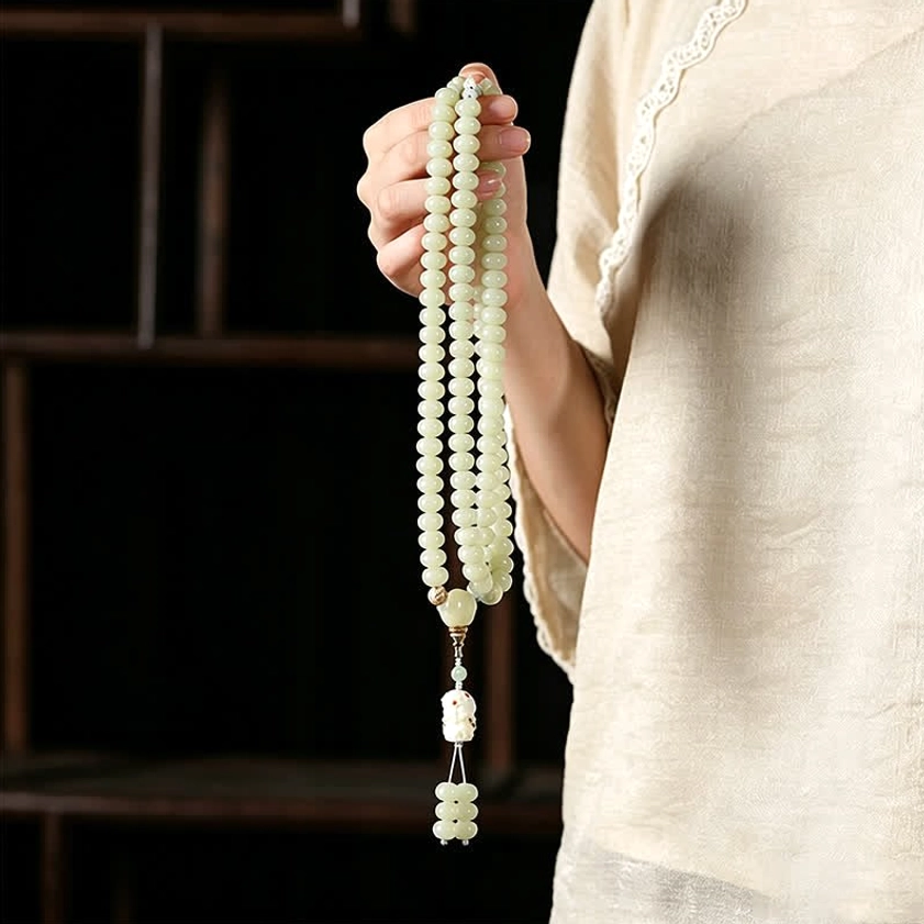 Person wearing beige linen holding full bodhi seed prayer mala necklace showing complete 108 bead display