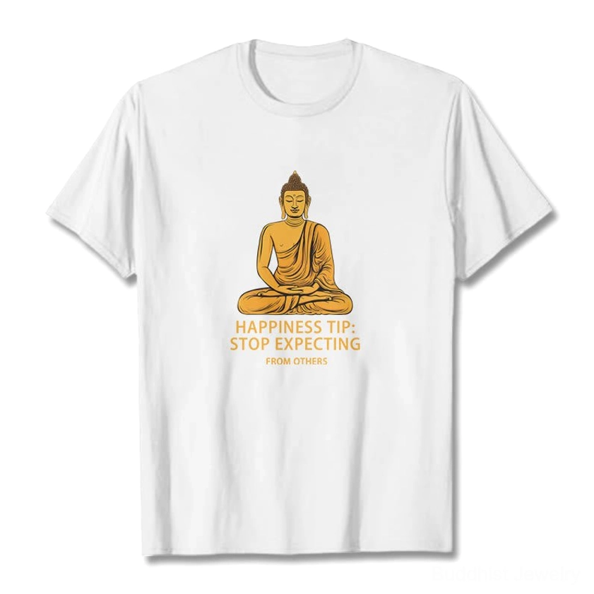 White Buddhist mindfulness graphic t-shirt with golden seated Buddha and 'Stop Expecting' text, front flat lay on white background