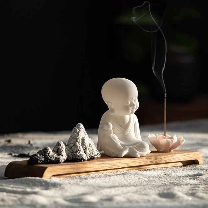 White ceramic Buddha incense burner figurine with intricate lotus design and natural wood base
