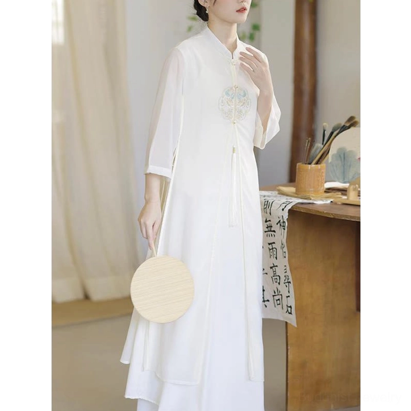 White chiffon meditation dress with sheer three-quarter sleeves, front three-quarter view with decorative fan accessory, showing embroidered chest detail