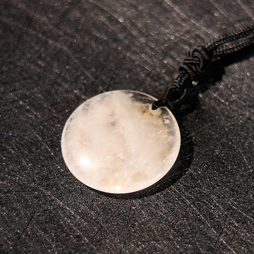 Clear quartz disc pendant with natural internal inclusions Buddhist swastika symbol gold accents