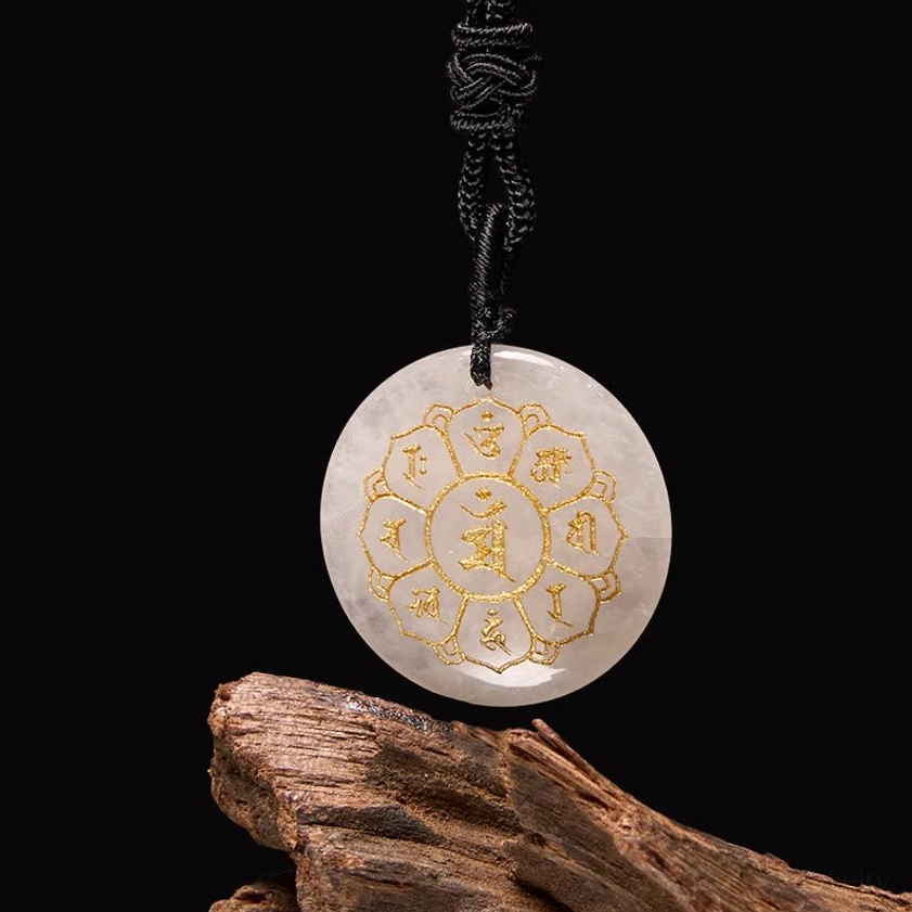 White Crystal Clear Quartz Om Mani Padme Hum Buddhist pendant with gold Sanskrit engraving on wooden background