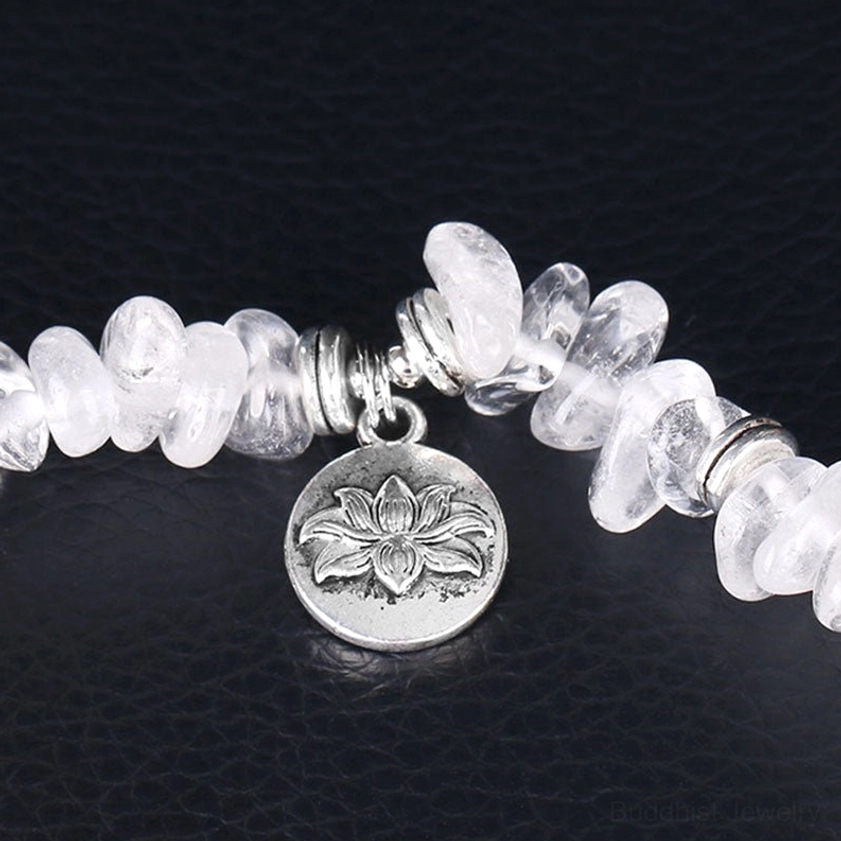 Macro close-up of white crystal beads and silver engraved lotus charm on bracelet