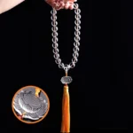 White crystal lotus mala bracelet with carved lotus pendant and yellow tassel, close-up detail shot