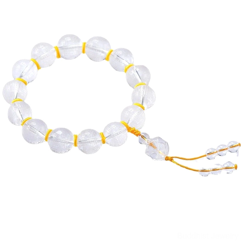 Clear white crystal prayer bracelet with smooth engraved beads, yellow cord tassel, and tiny crystal pendants on dark flat lay background