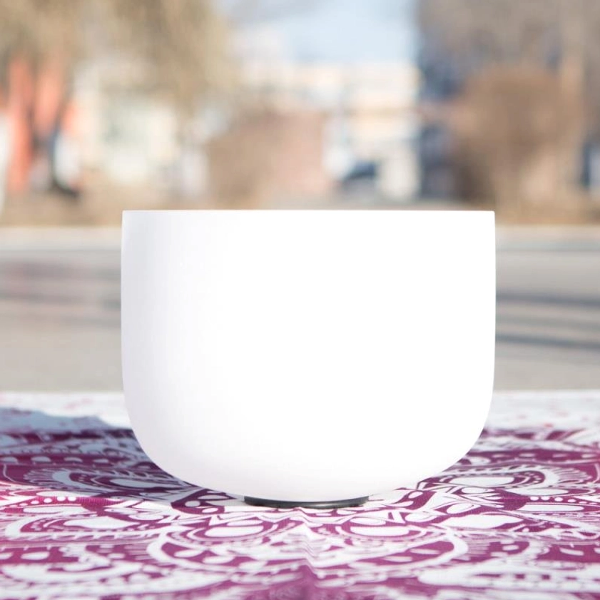 White frosted crystal singing bowl with matte finish and anti-slip base on outdoor mandala tabletop