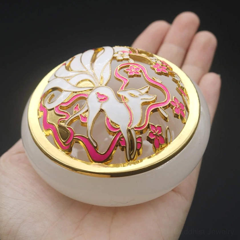 Handheld white jade-style nine-tailed fox incense burner first-person overhead view with gold border and pink floral decorative cloisonne details