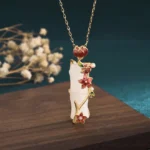 White jade bamboo lotus necklace pendant with red enamel flowers and gold-plated accents, handcrafted Buddhist symbol jewelry for protection and spiritual enlightenment