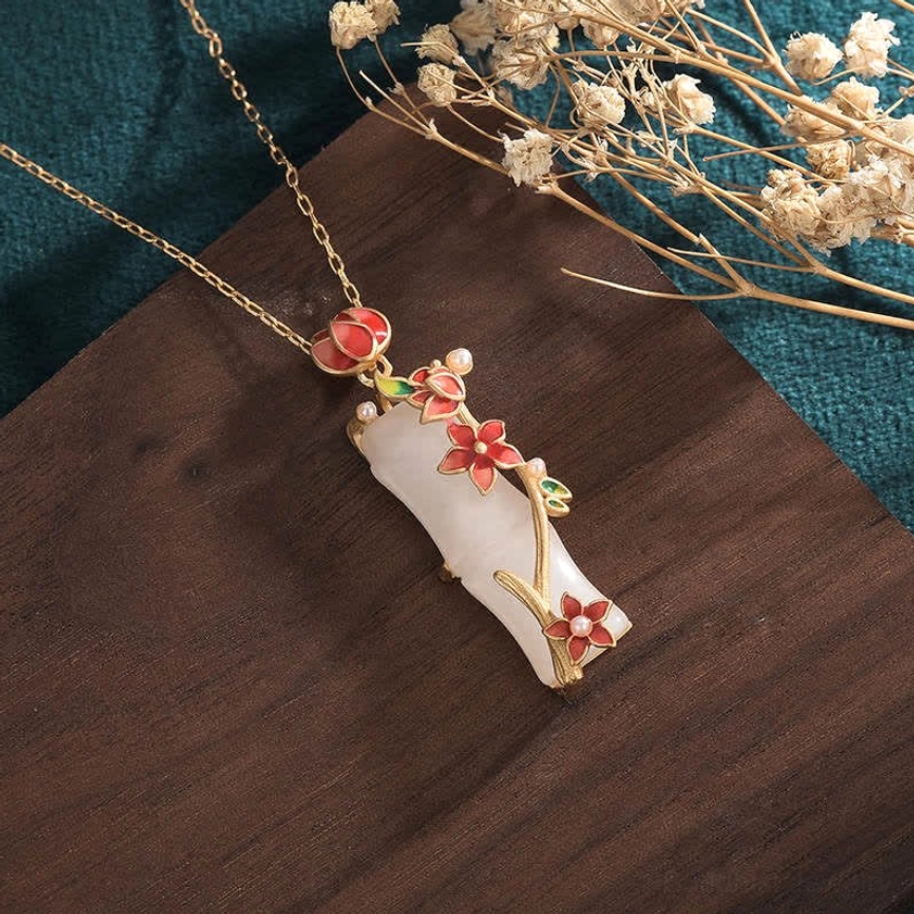 Detailed side view of white jade bamboo lotus Buddhist necklace showing intricate red enamel blossom details and gold-tone chain, spiritual protection pendant