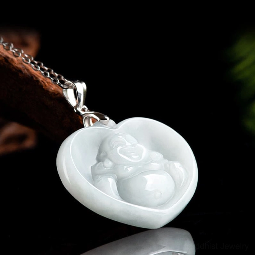 Three-quarter side view of heart-shaped white jade Buddhist pendant with carved smiling Buddha figure