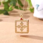 White jade double dorje gold plated locket necklace flat lay with protective symbols and ornate frame design