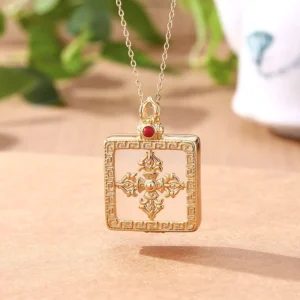 White jade double dorje gold plated locket necklace flat lay with protective symbols and ornate frame design