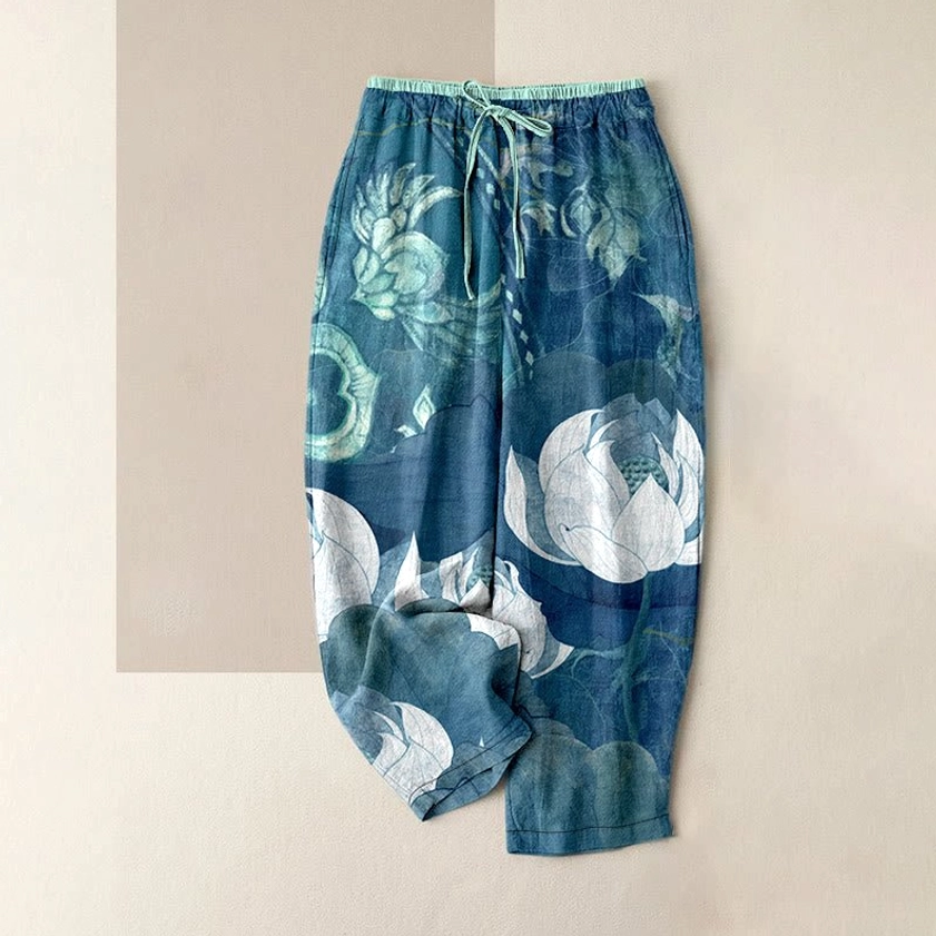 Women's blue harem pants with white lotus floral print and elastic waist drawstring front flat lay view