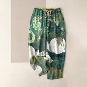 Women's white lotus harem pants front view with green base color and white lotus leaf print pattern