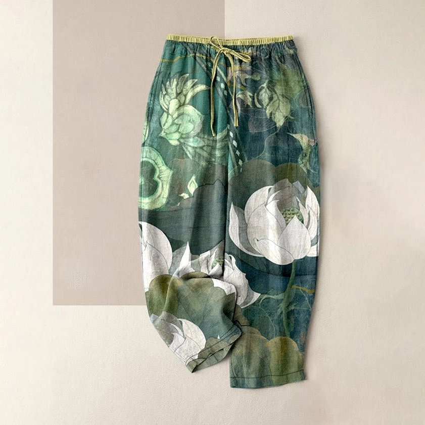 Women's white lotus harem pants front view with green base color and white lotus leaf print pattern