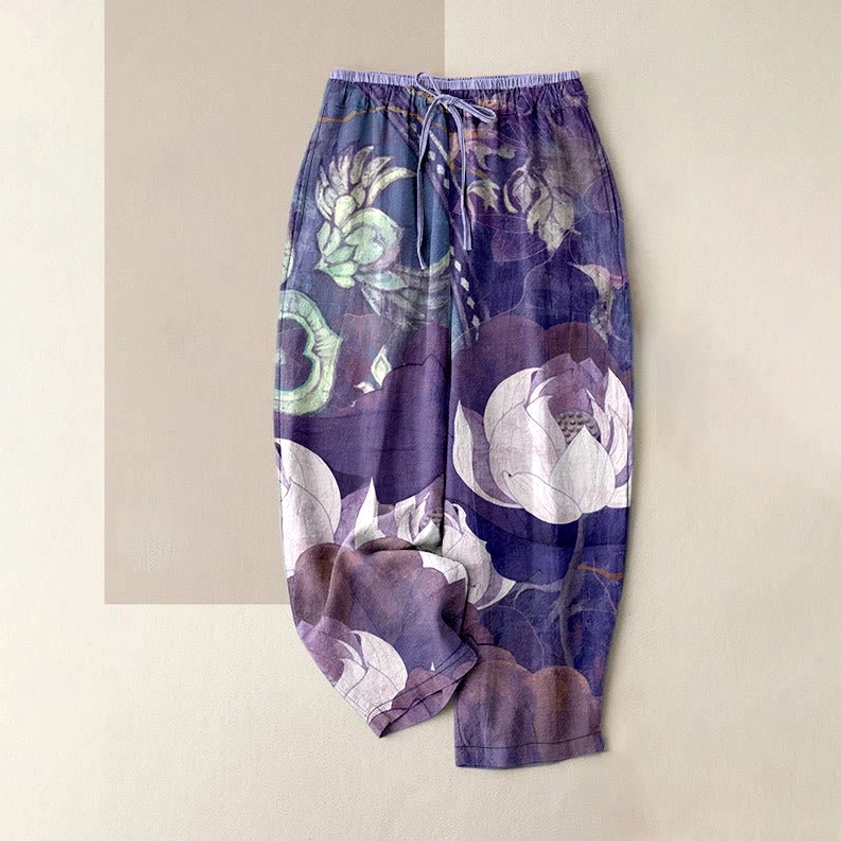 Women's purple harem pants featuring white lotus botanical print with drawstring waist and relaxed fit