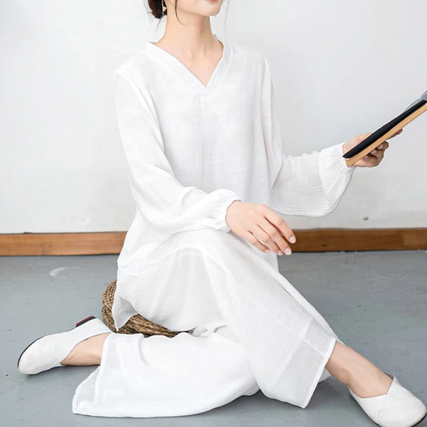 Woman seated in white meditation two-piece set demonstrating comfort and flexibility