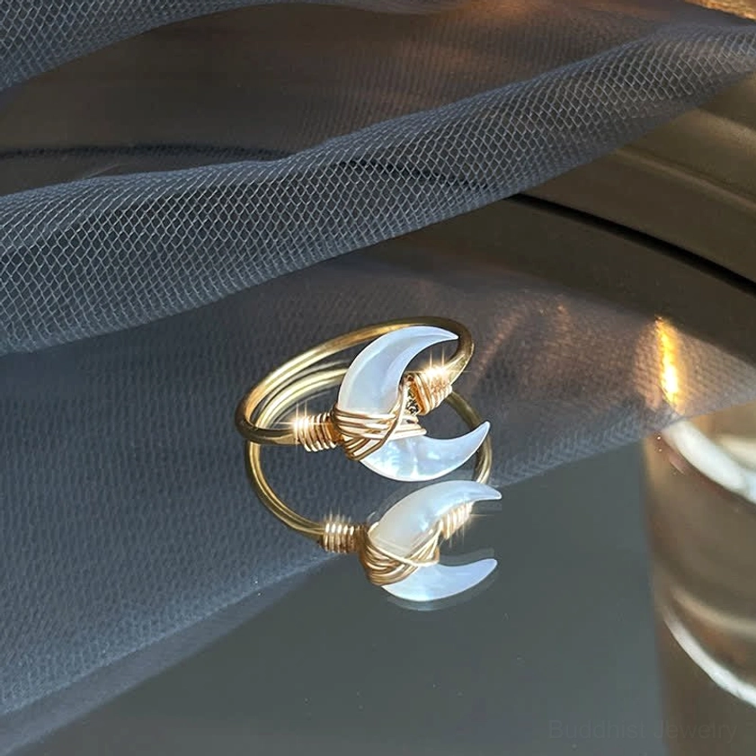 White tridacna stone moon ring close-up, twisted 14K gold wire design with shadow reflection