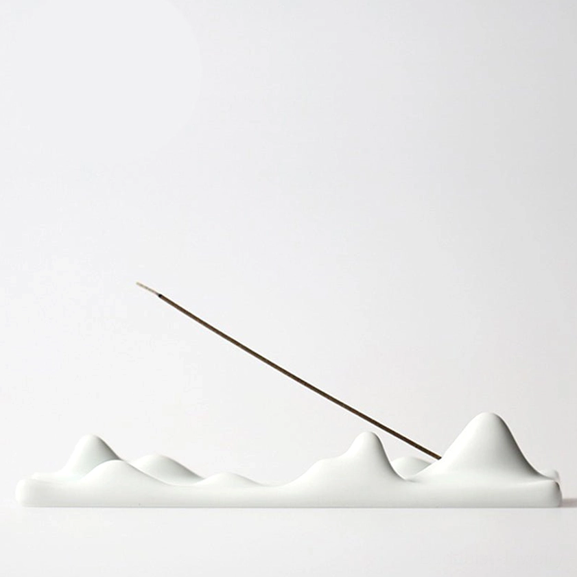 White ceramic mountain peak incense holder with multi-peak design, front view on white background