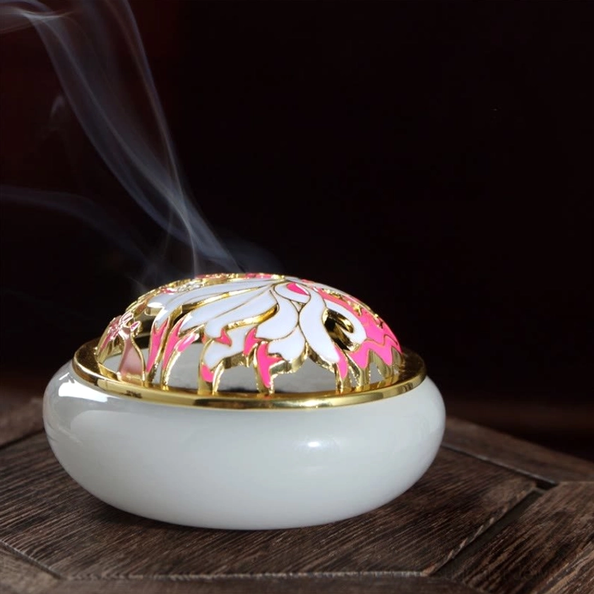 White jade-style nine-tailed fox incense burner close-up front view with smooth body, gold trim, pink floral cloisonne carved lid, and rising incense smoke