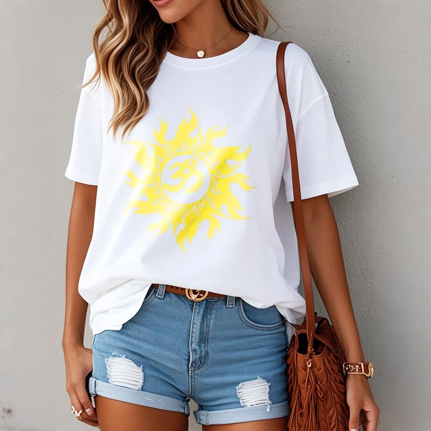 Woman in white Om sun Buddhist t-shirt loose fit, styled with denim shorts and brown bag, outdoor setting