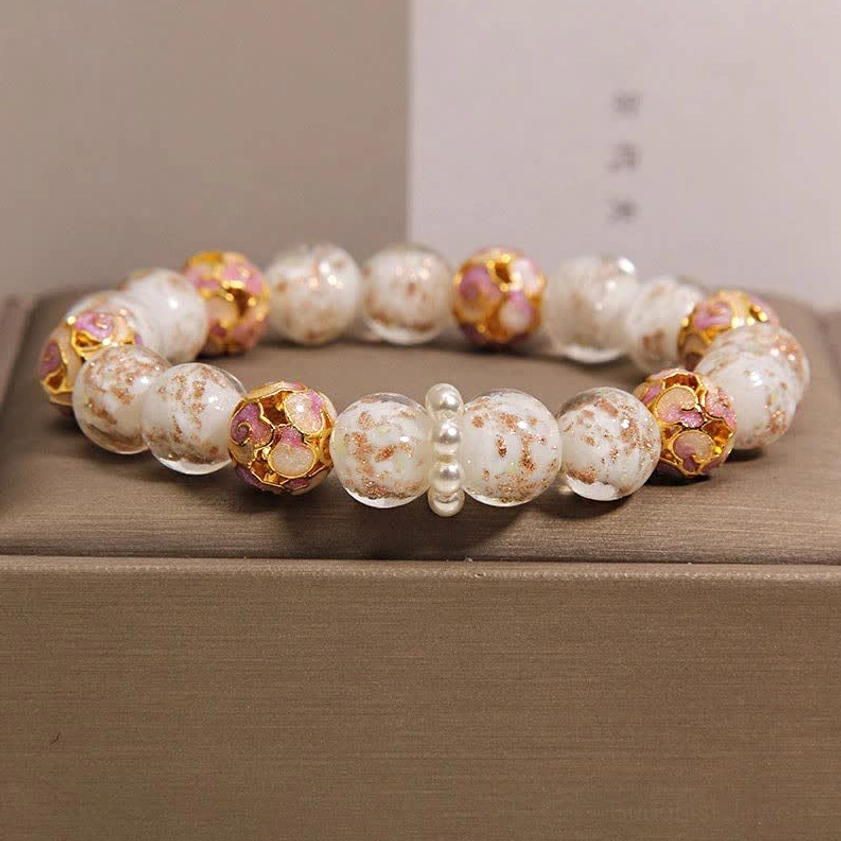 White pearl and enamel beaded Buddhist bracelet with gold-decorated cloisonné accents flat lay