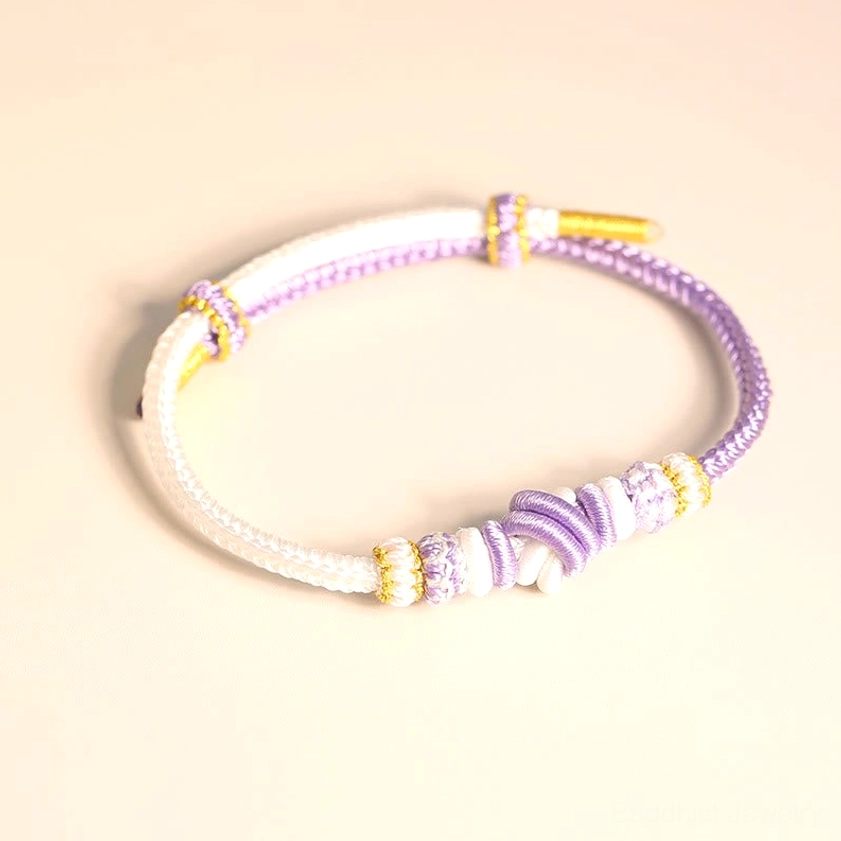 White and purple handwoven Buddhist bracelet with sacred eight-thread knot for spiritual protection and luck