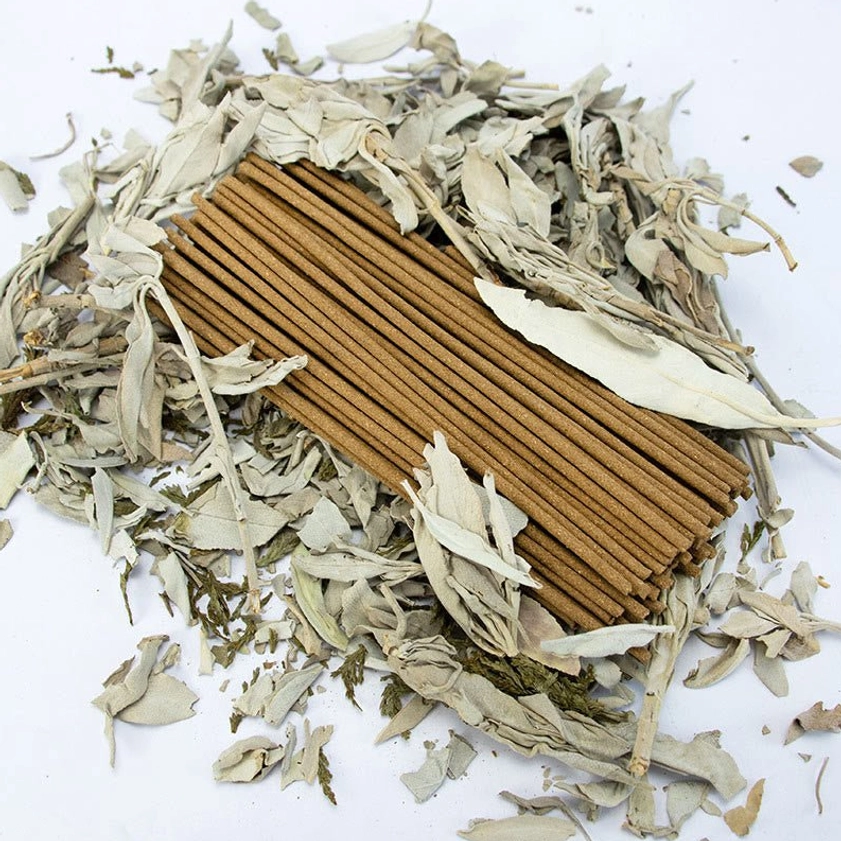 Flat lay composition of white sage incense sticks with scattered dried sage and pure studio white background
