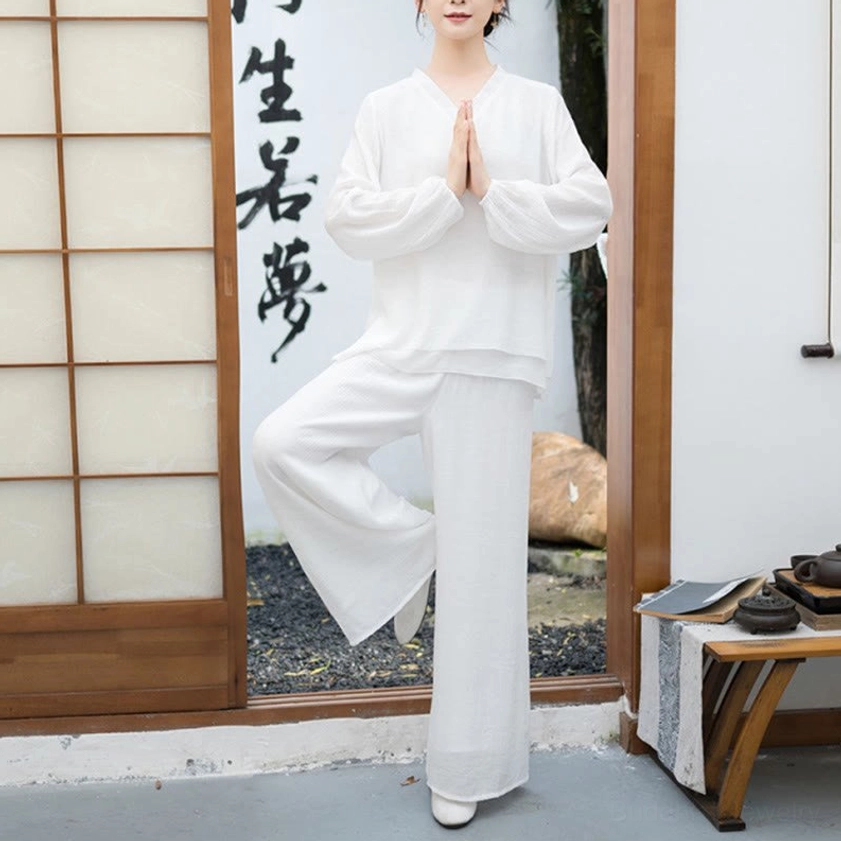 Woman wearing white Tai Chi meditation suit in prayer pose on Japanese-style interior