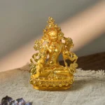 White Tara gold plated Buddha statue front view with ornate crown and gem-inlaid details on lotus base