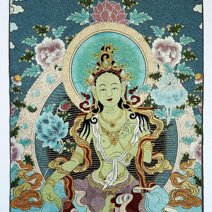 Macro close-up of White Tara Buddhist embroidery thangka tapestry showing deity adornments and detailed border embroidery