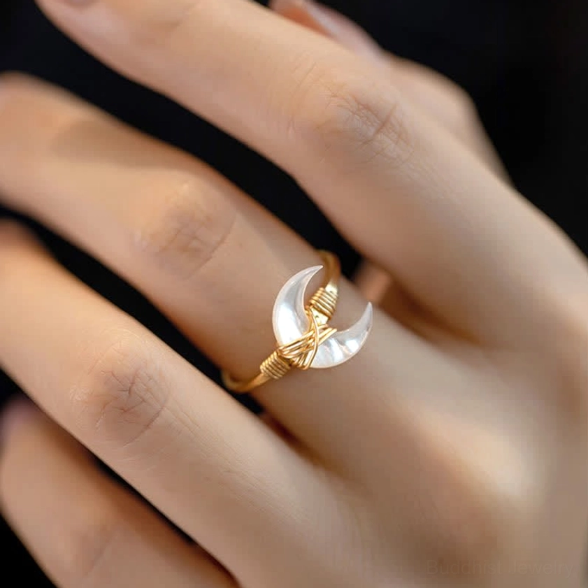 White tridacna stone moon blessing ring on finger, front close-up showing 14K gold wrapped crescent moon charm