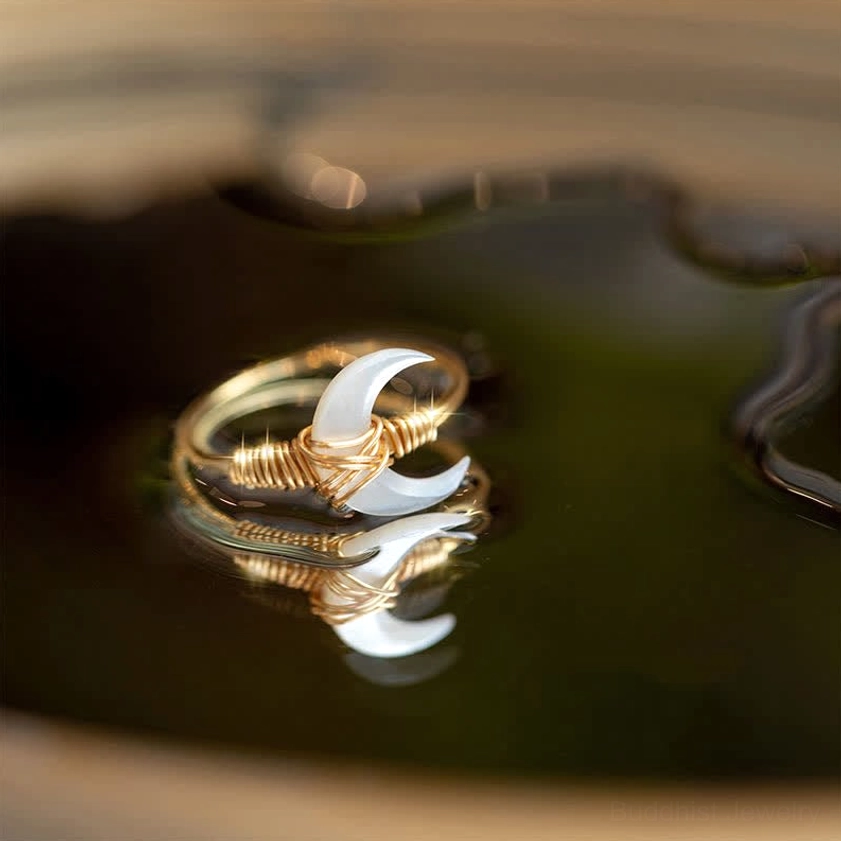 White tridacna stone moon blessing ring with 14K gold wire wrapping, overhead close-up view showing crescent moon charm detail