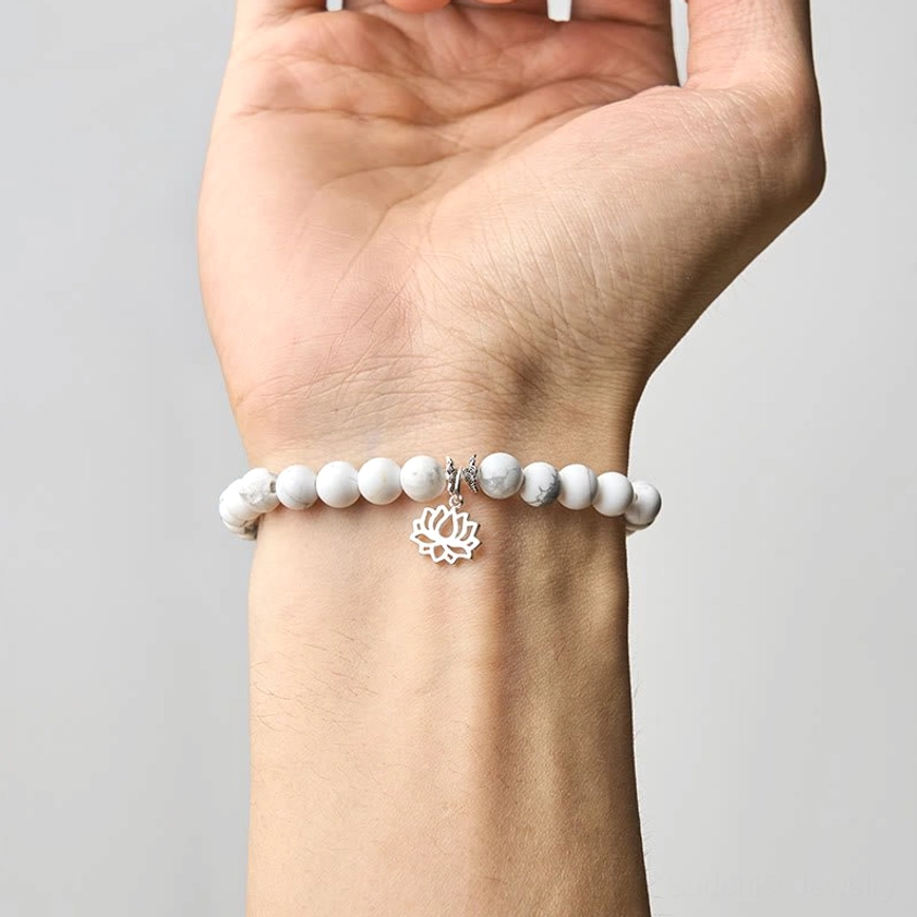 Woman wearing white turquoise lotus bracelet on wrist demonstrating proper fit and styling of handmade Buddhist bracelet
