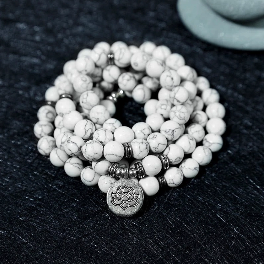 108 bead white turquoise lotus mala bracelet topdown view showing grey veined stone beads and silver lotus pendant on black background