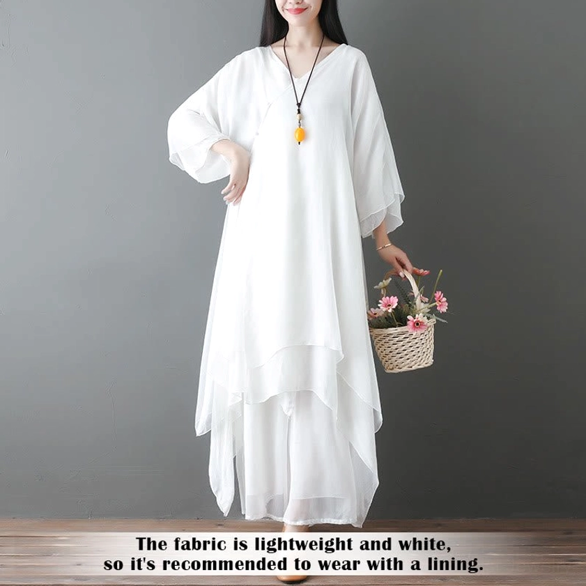 White Zen dance clothing set side profile view with asymmetric flowy hem on wooden floor studio setting