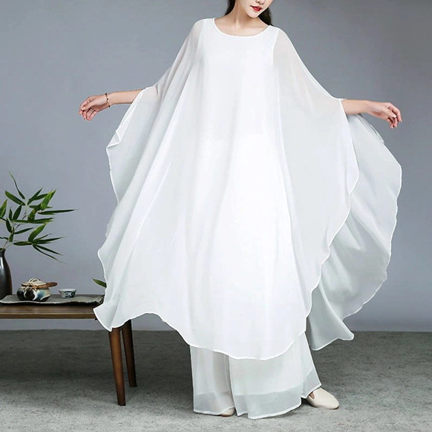 White two-piece Zen meditation set with cape-style sleeves in dynamic pose demonstrating unrestricted movement for yoga