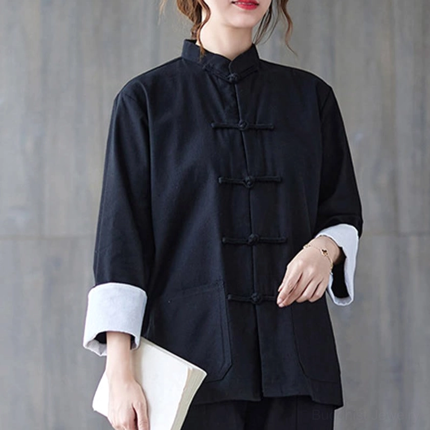 Side profile of women wearing black frog-button meditation shirt with hand on waist pose