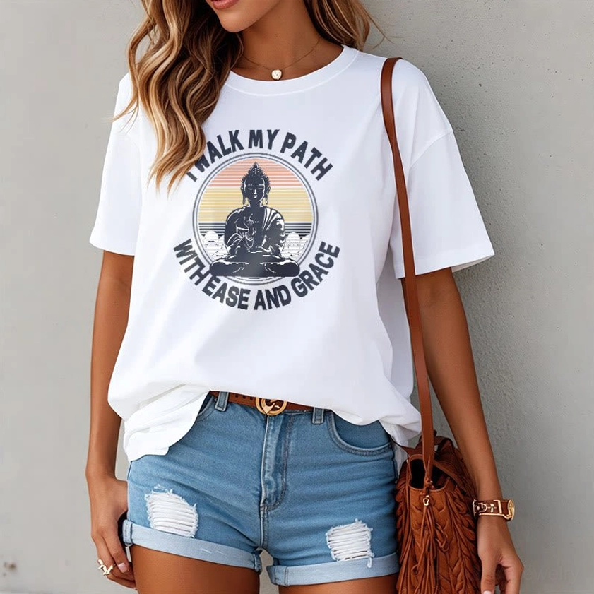 Woman wearing white Buddhist spiritual graphic t-shirt with denim shorts brown bag casual look