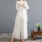 Women's linen meditation two-piece set with frog buttons - front full-body view showing asymmetrical hem top and wide-leg pants in off-white color for yoga and spiritual practices