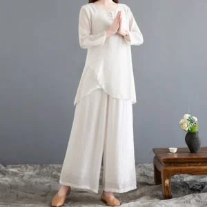 Women's linen meditation two-piece set with frog buttons - front full-body view showing asymmetrical hem top and wide-leg pants in off-white color for yoga and spiritual practices