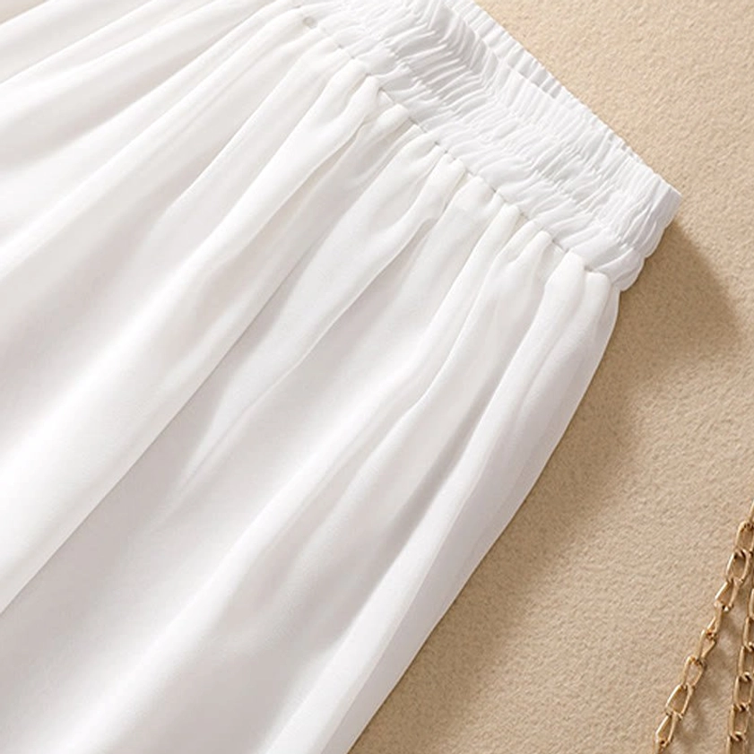 Side profile of women's meditation ensemble showing tunic length relative to white wide leg pants