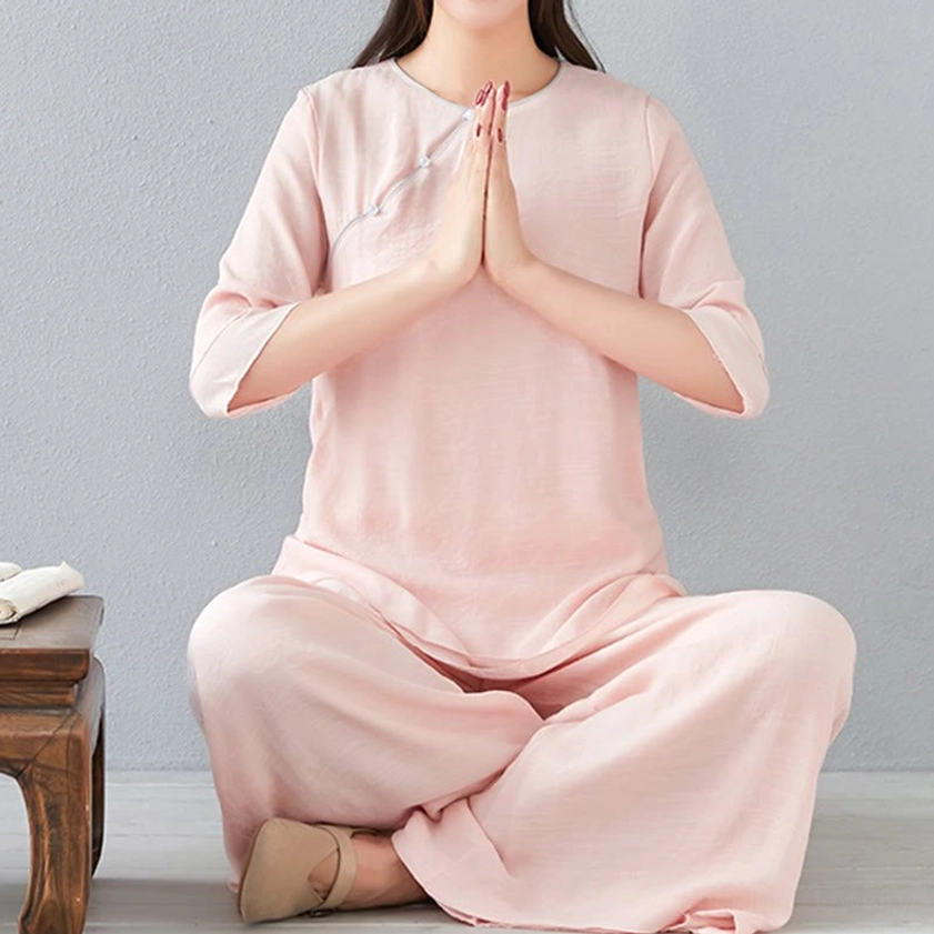 Three-quarter length view of woman wearing white meditation cotton linen set showing three-quarter sleeve length and wide-leg pant width