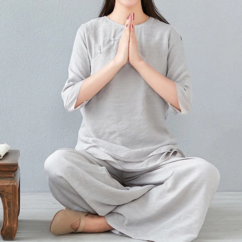 Model in white three-quarter sleeve meditation cotton linen outfit with loose-fitting wide-leg pants, front facing pose