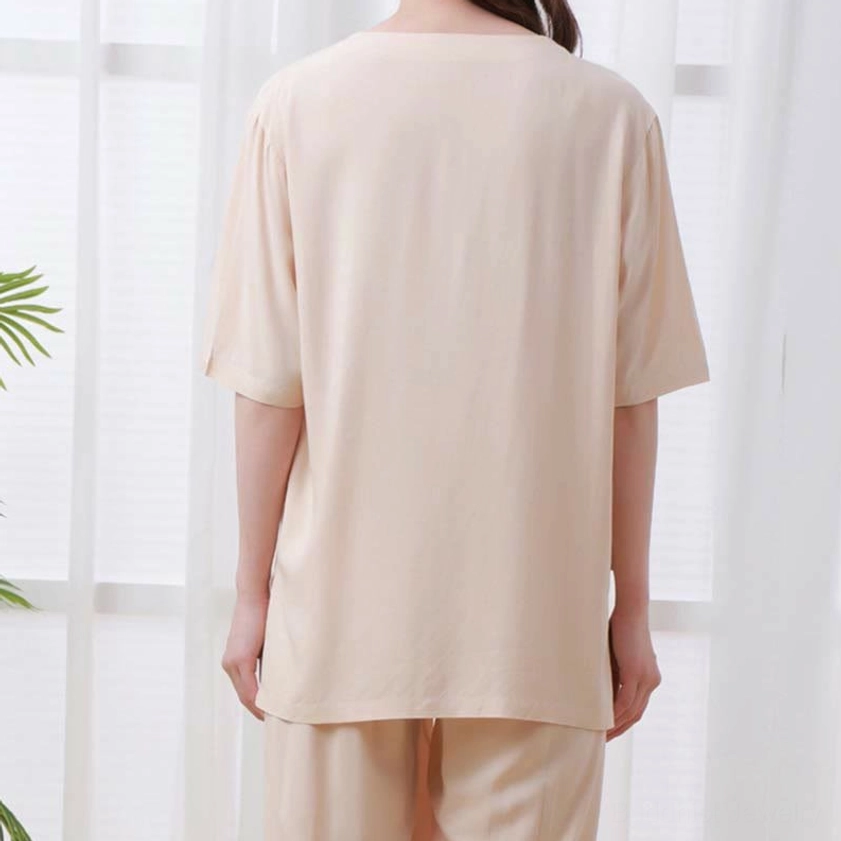 Back view of beige meditation clothing set showing half sleeve crew neck top and straight hemline of elastic waist pants