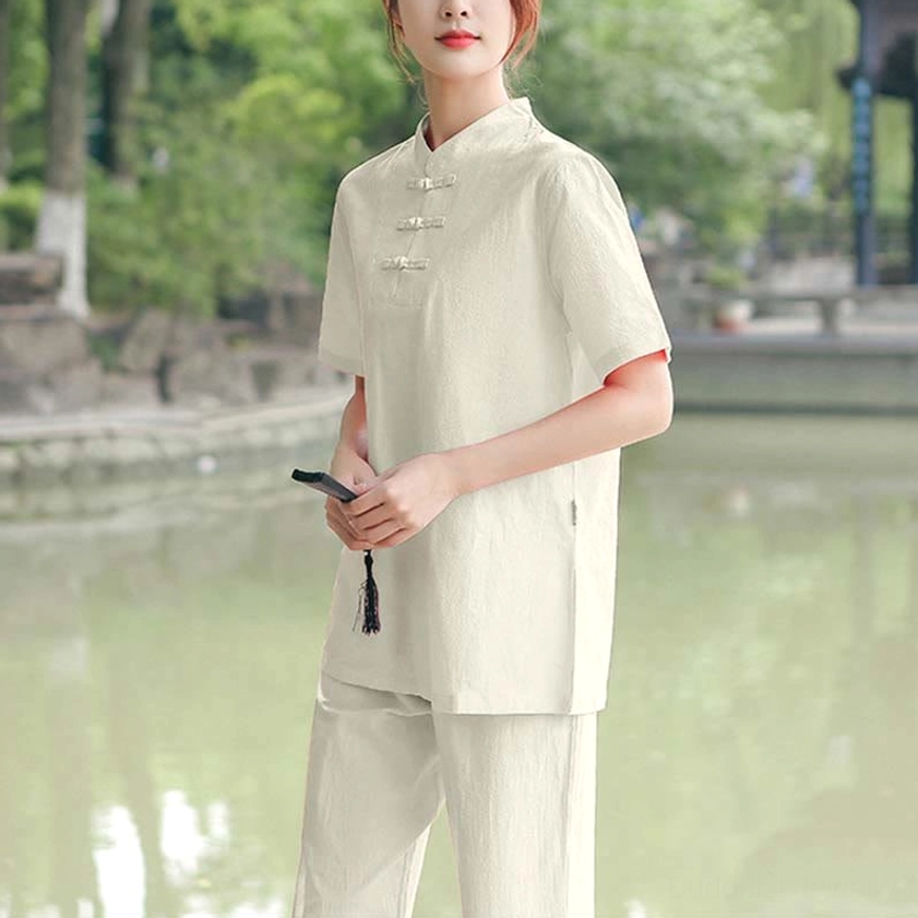 Cream-colored meditation and tai chi set showcasing traditional stand collar design and relaxed fit in waterside garden