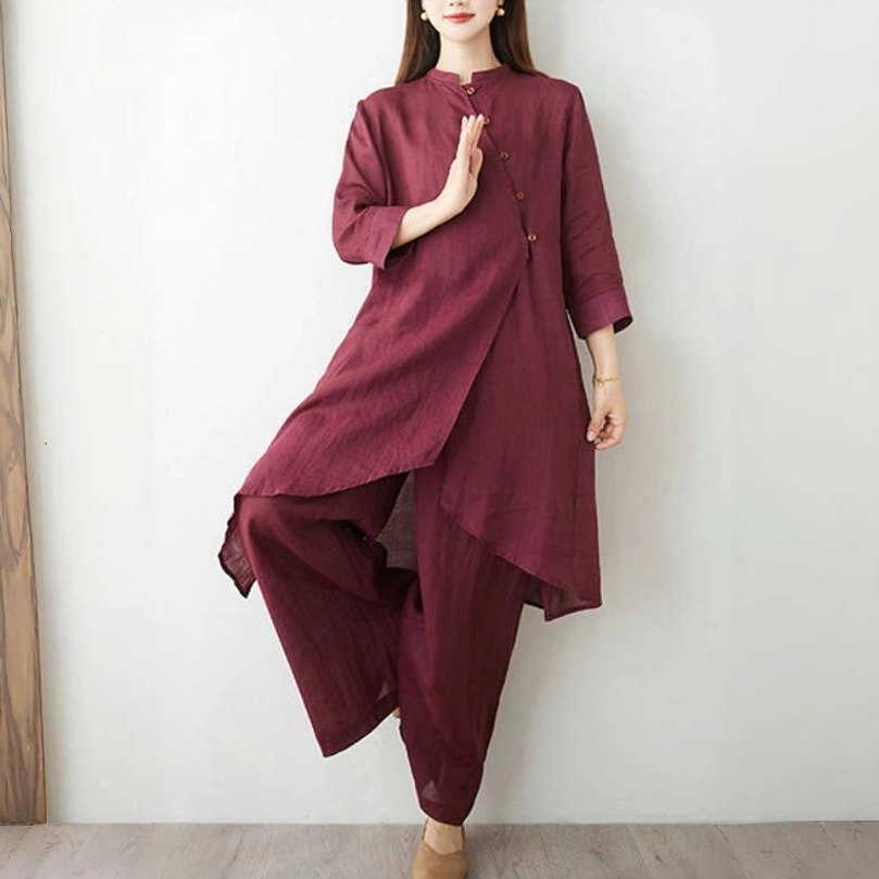 Burgundy cotton linen meditation suit dynamic pose showing diagonal button placket and semi-sheer fabric