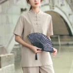 Women's khaki cotton-linen meditation and tai chi clothing set with stand collar, front full-body view in traditional garden setting