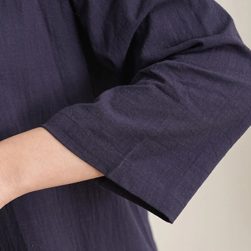 Women in navy blue meditation clothing practicing seated zen meditation indoors